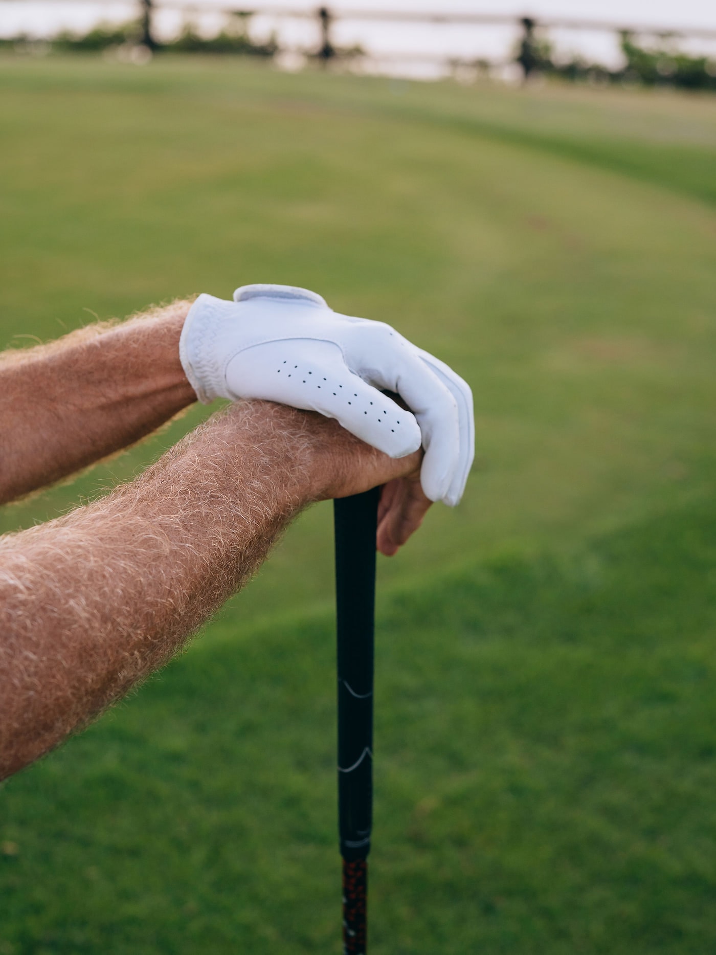 Gloved hands resting on the grip of a club