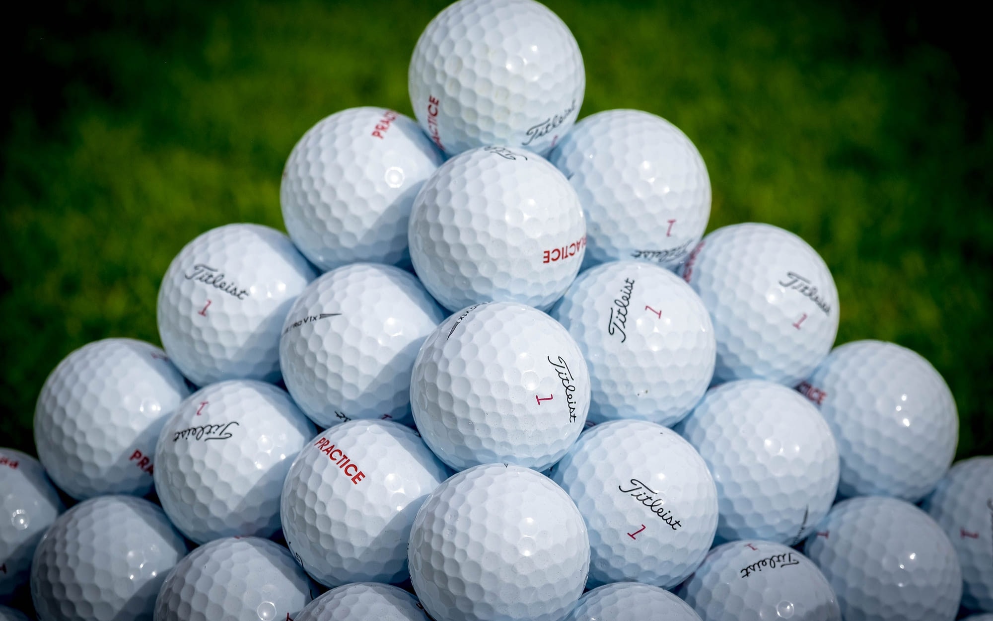 A stack of practice balls waiting on the grass