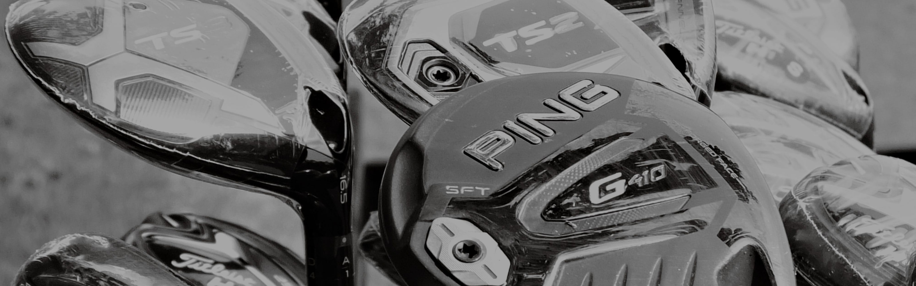 Driver and fairway wood heads standing in a rack