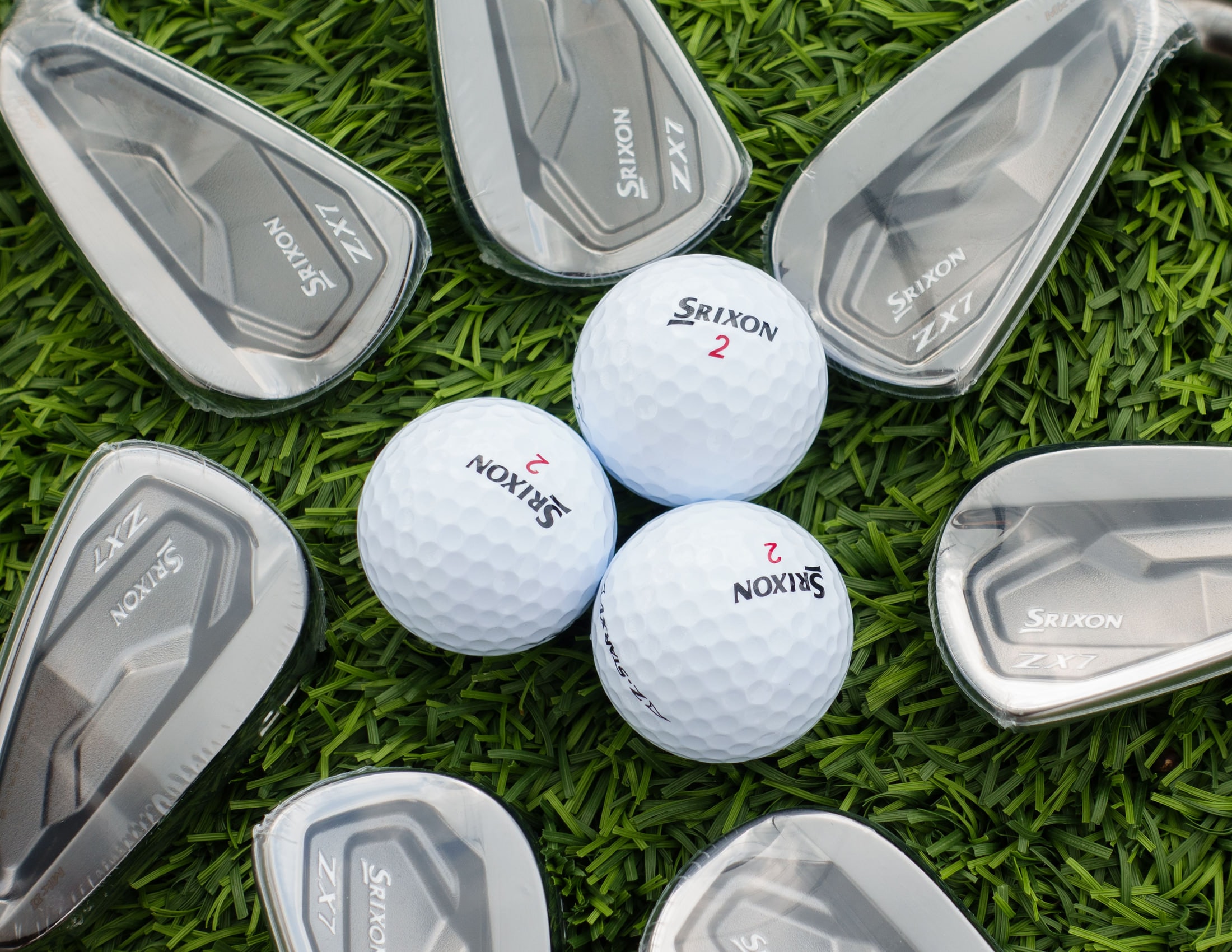 Srixon iron heads and balls lying on cut grass