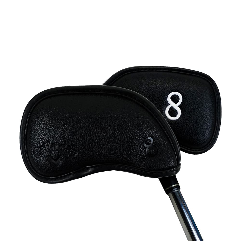 A black Callaway magnetic iron headcover on an iron, on white